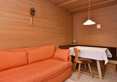 a bedroom with a white bed with a wooden headboard at Post Hotel Moena in Moena