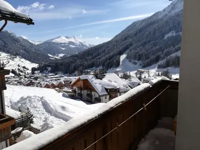 a view from a balcony of a town in the snow at Appartamento Gliera in Arabba