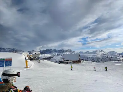 a group of people skiing down a snow covered slope at Appartamento Gliera in Arabba