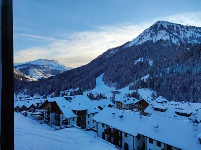 a village covered in snow with mountains in the background at Appartamento Gliera in Arabba