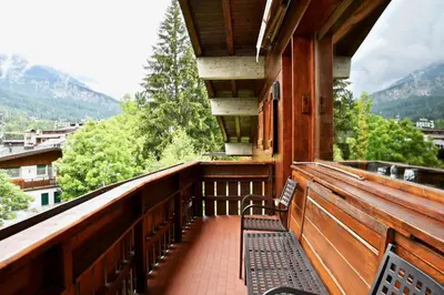 a balcony of a house with a view of the mountains at CanguroProperties - Ca' Mora in Cortina dʼAmpezzo