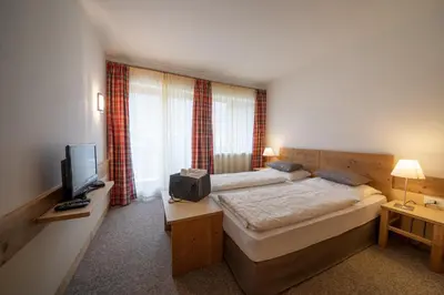a hotel room with a bed and a television at Pöder - daheim in den Bergen in Ultimo