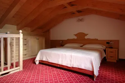 a bedroom with a large bed in a attic at Residence Pez Gajard in San Martino di Castrozza