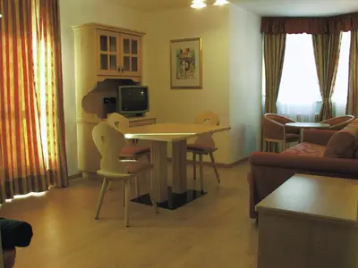 a living room with a table and chairs and a couch at Residence Pez Gajard in San Martino di Castrozza