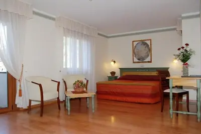 a bedroom with a bed and a table and chairs at Parkhotel Fedora in Campitello di Fassa