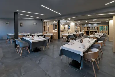 a dining room with white tables and chairs at Parkhotel Fedora in Campitello di Fassa