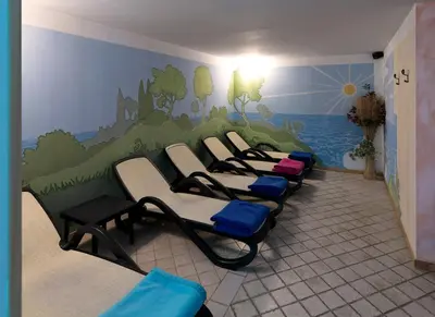 a row of chairs in a waiting room with a mural at Parkhotel Fedora in Campitello di Fassa