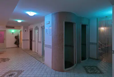 a bathroom with pink and green walls and a tile floor at Parkhotel Fedora in Campitello di Fassa