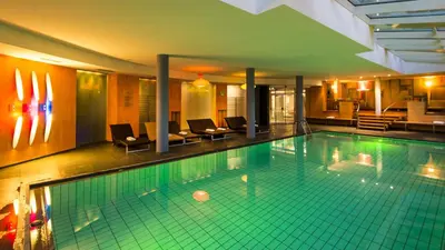 a large swimming pool with chairs in a hotel at Hotel St. Anton in Fiè