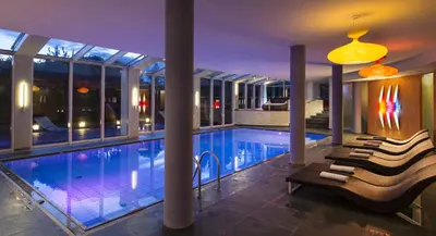 a swimming pool with chairs next to a building at Hotel St. Anton in Fiè