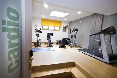 a gym with treadmills and ellipticals in a room at Hotel St. Anton in Fiè