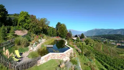 an aerial view of a garden with a pond at Tirolerhof Tisens in Tesimo