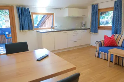a living room with a table and a kitchen at Tirolerhof Tisens in Tesimo