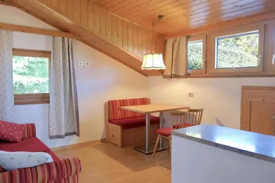 a kitchen and living room with a table and chairs at Tirolerhof Tisens in Tesimo