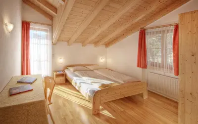 a bedroom with a bed and a desk and windows at Ferienhof 