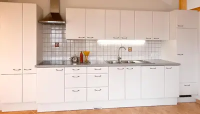a kitchen with white cabinets and a sink at Ferienhof 