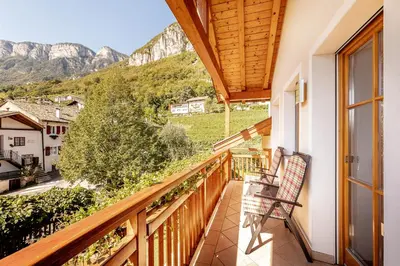 a balcony with a chair and a view of mountains at Ferienhof 