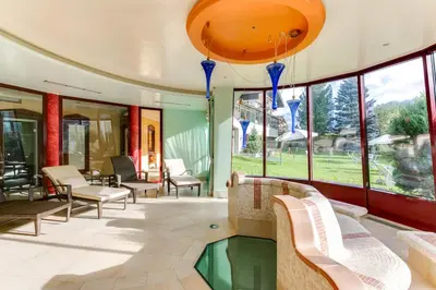 a lobby with chairs and a pool in a building at Smy Koflerhof Wellness & Spa Dolomiti in Rasun di Sopra