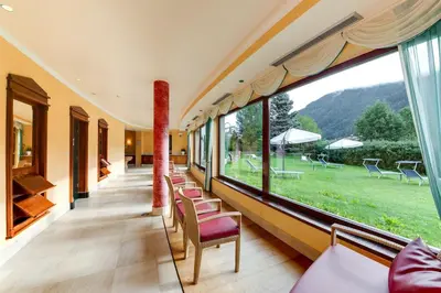 a room with a large window with chairs and a field at Smy Koflerhof Wellness & Spa Dolomiti in Rasun di Sopra