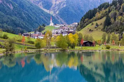 a lake with a small town in the mountains at Smy Koflerhof Wellness & Spa Dolomiti in Rasun di Sopra