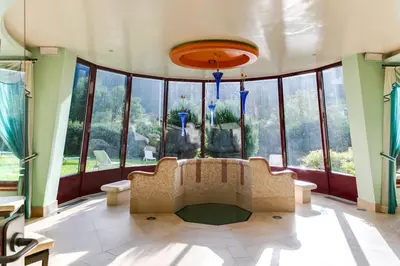 a large room with a couch and large windows at Smy Koflerhof Wellness & Spa Dolomiti in Rasun di Sopra