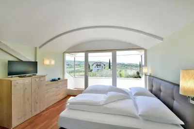 a bedroom with a bed and a large window at Villa Raifer in Appiano sulla Strada del Vino