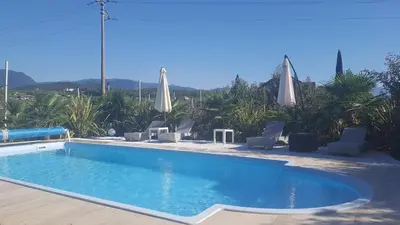 a swimming pool with chairs and umbrellas at Villa Raifer in Appiano sulla Strada del Vino