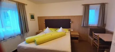 a bedroom with a large wooden cabinet and two chairs at Garni Halali in Ortisei