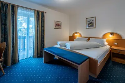 a bedroom with a bed with a colorful comforter at Garni Halali in Ortisei