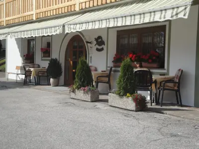 a restaurant with tables and chairs and a table with flowers at Garni Halali in Ortisei