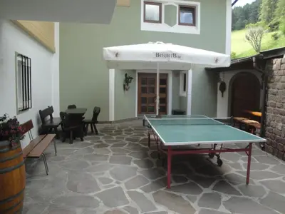 a ping pong table in the middle of a patio at Garni Halali in Ortisei