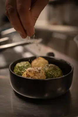 a person is cooking food in a pan at Hotel Olangerhof in Valdaora