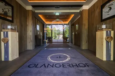 a hallway with a welcome mat in a hotel lobby at Hotel Olangerhof in Valdaora