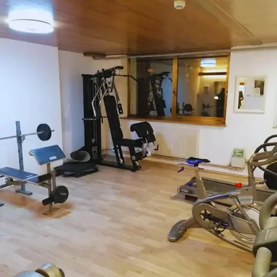 a gym with several exercise equipment in a room at Hotel Trento in Pozza di Fassa