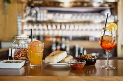 a table with drinks and food on a bar at Hotel Trento in Pozza di Fassa