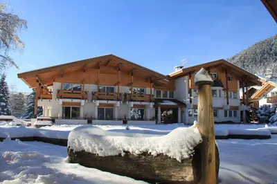 a large building with snow in front of it at Hotel Trento in Pozza di Fassa