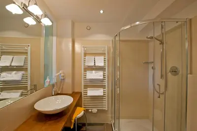 a bathroom with a sink and a shower at Hotel Schennerhof in Schenna