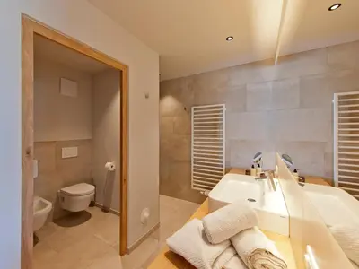 a bathroom with a sink and a toilet at Hotel Schennerhof in Schenna