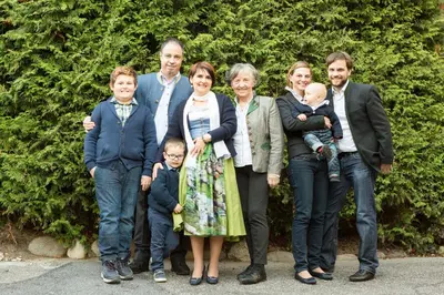 a family posing for a picture in front of a bush at Hotel Schennerhof in Schenna