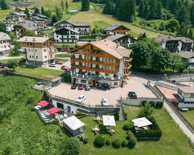 an aerial view of a large building in a village at Hotel Al Parco in Moena
