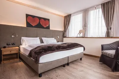 a bedroom with a large bed with hearts on the wall at Hotel Al Parco in Moena