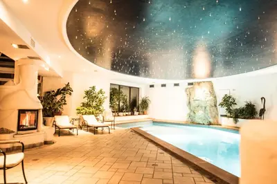 a large indoor pool with a star ceiling at Hotel Enzian in Siusi