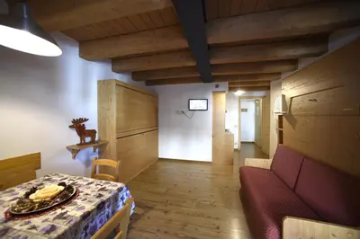 a living room with a table and a couch at Residence Civetta in Val di Zoldo