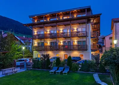 a large building with a lawn in front of it at Hotel Rose in Villabassa