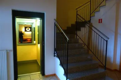 a staircase in a building with a person taking a picture at Garni Cremona in Bressanone