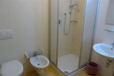 a bathroom with a shower and a toilet and a sink at Garni Cremona in Bressanone