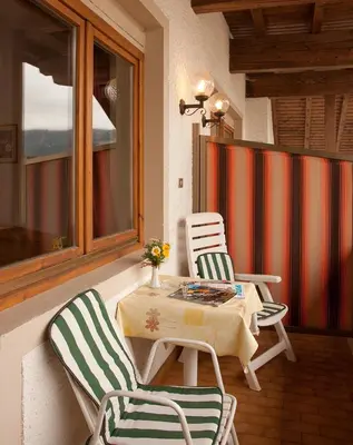 a patio with two chairs and a table and a table and two chairs at Hotel Rainegg in Valdaora