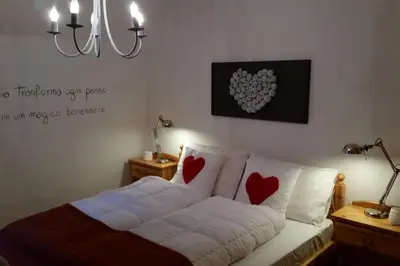 a bedroom with a bed with hearts on the wall at il bosco in casa in Telve