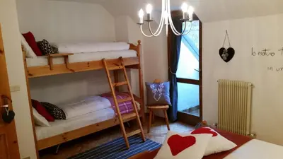 a room with two bunk beds and a chandelier at il bosco in casa in Telve