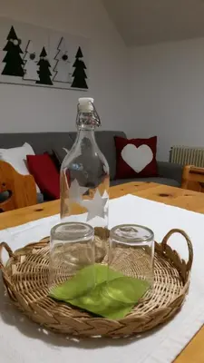 a bottle and glasses in a basket on a table at il bosco in casa in Telve